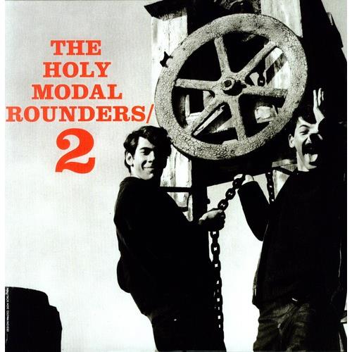 Black and white album cover featuring two men standing near a large metal pulley wheel