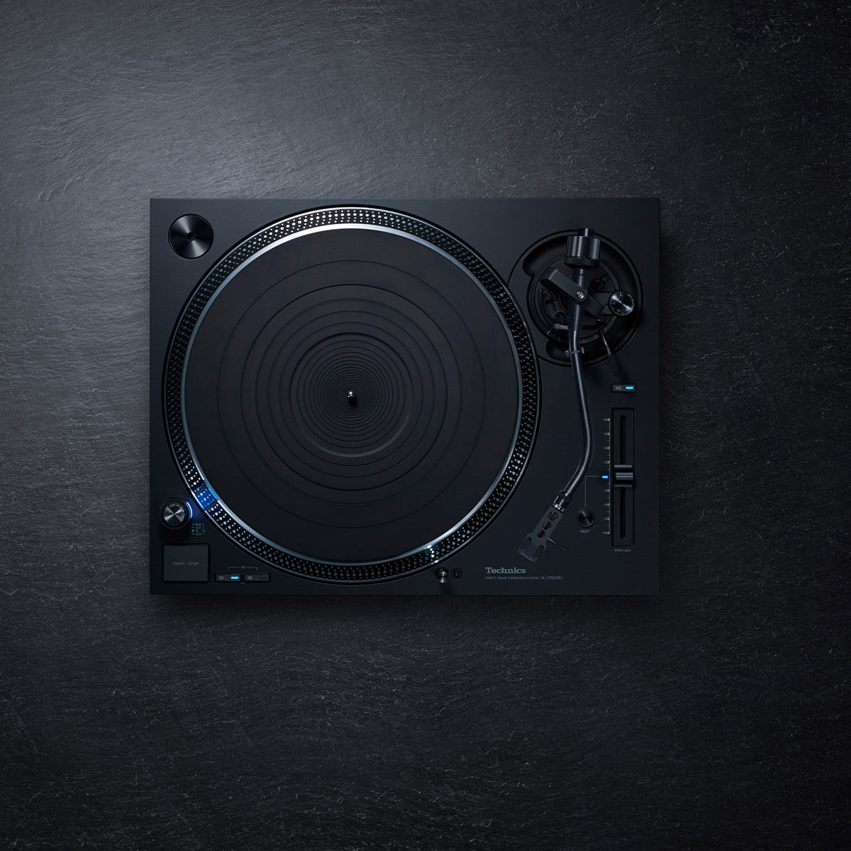 Black direct-drive turntable with a strobe-lit platter and S-shaped tonearm