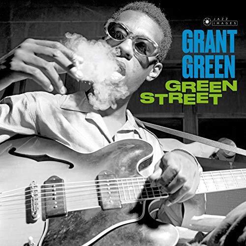 Black and white portrait of a man wearing sunglasses and smoking while playing a hollow-body electri