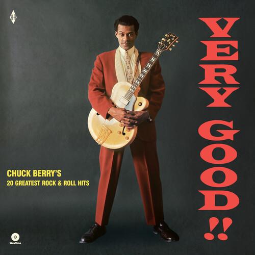 Chuck Berry standing in a rust-colored suit holding a cream electric guitar