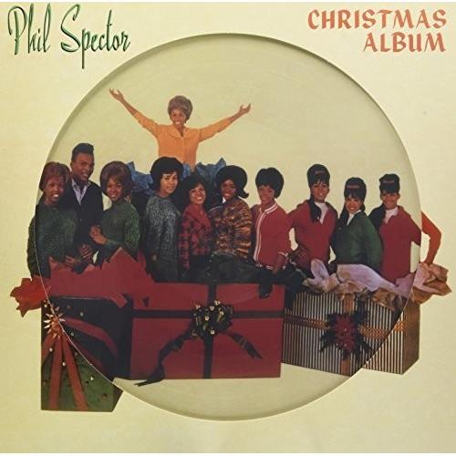 Vintage Christmas album cover featuring a group of singers in colorful sweaters emerging from a larg