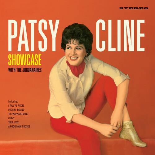 Orange vinyl album cover featuring a woman in a white jacket and red pants sitting on a ledge