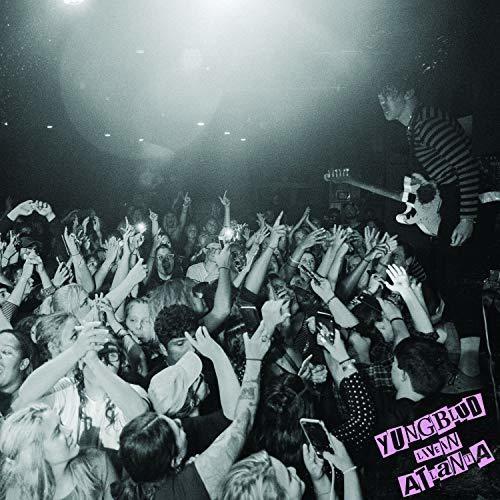 Black and white concert photo of a guitarist performing for a crowd with raised hands