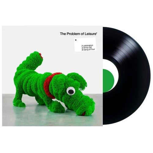 Green plush dog sculpture with red collar on white album cover next to black vinyl record