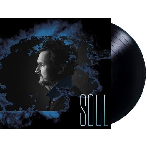 Black vinyl record partially removed from a dark album cover featuring a man's profile and blue smok