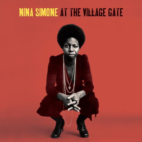 Nina Simone crouching in a red dress and layered necklaces against a red background