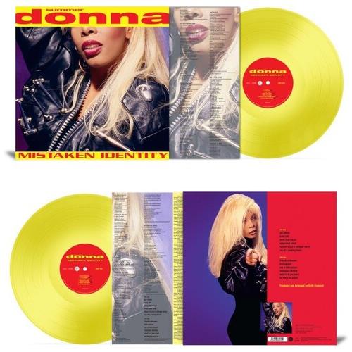 Translucent yellow vinyl record with red center label and album cover featuring a woman in a black l