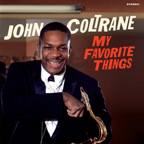 John Coltrane smiling while holding a saxophone on the album cover