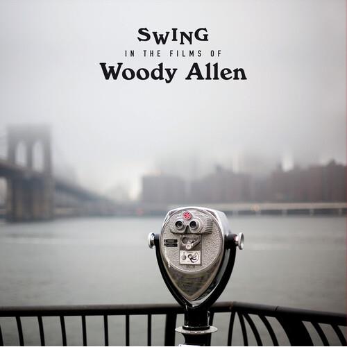 Silver coin-operated binoculars on a railing with a foggy bridge and city skyline in the background