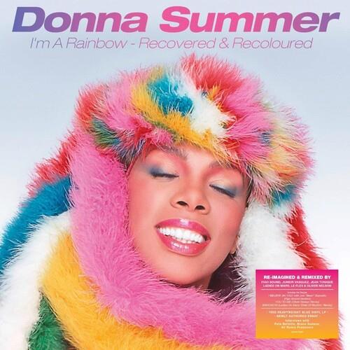 Donna Summer wearing a multicolored faux fur hood with eyes closed and smiling