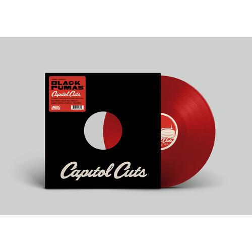 Red translucent vinyl record partially removed from a black sleeve with white and red circular desig