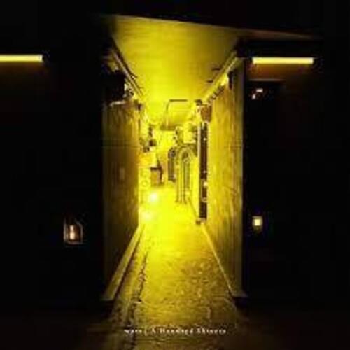 Yellow-tinted photograph of a dimly lit hallway with a figure at the end