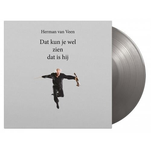Silver colored vinyl record partially removed from a light gray album sleeve featuring a man in a bl