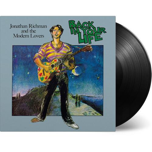 Illustrated album cover showing a man playing a colorful guitar against a night sky with a black vin