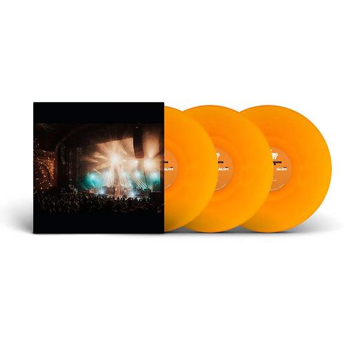 Translucent orange vinyl records displayed next to a black album sleeve featuring a concert stage