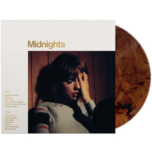Mahogany marbled vinyl record partially removed from white album sleeve with gold text