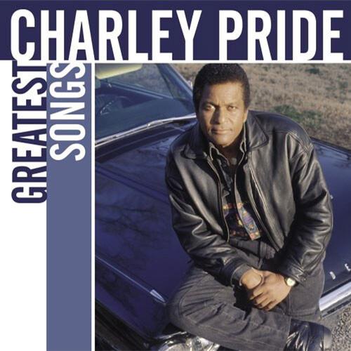 Charley Pride in a black leather jacket leaning against a blue car