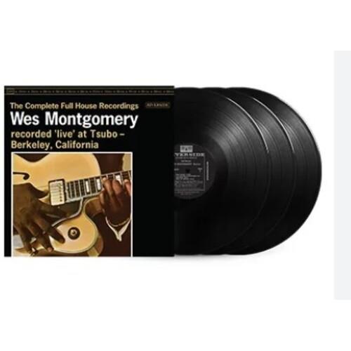 Three black vinyl records displayed next to a black album cover featuring a guitarist