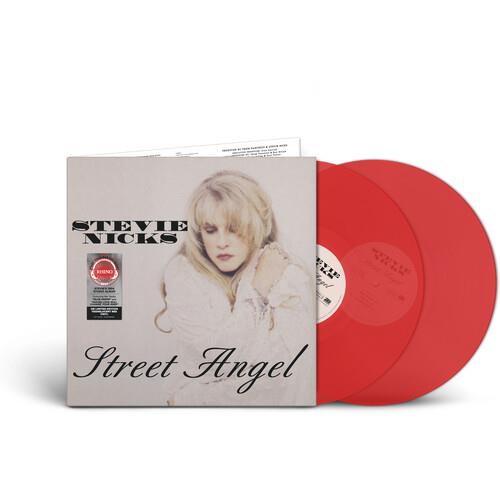 Transparent red vinyl LPs displayed next to a white album cover featuring a portrait of a blonde wom