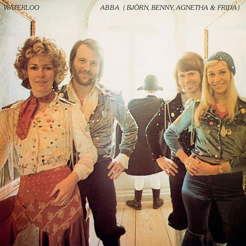 Four band members in 18th-century costumes posing in a hallway