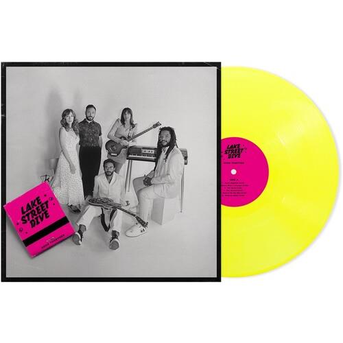 Neon yellow vinyl record with a pink center label next to a black and white album cover