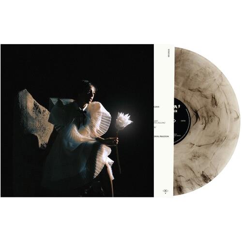Milky white and black marbled vinyl record partially removed from a black album sleeve featuring a p