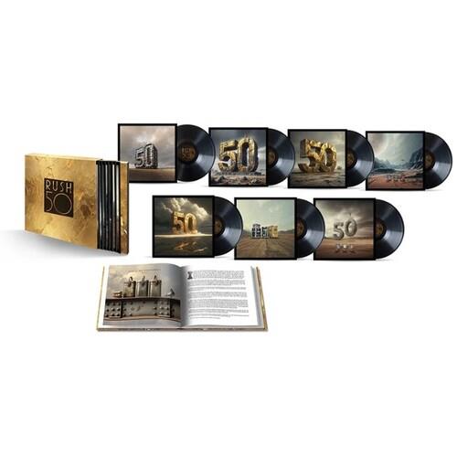 Gold box set containing seven vinyl records and an open hardcover book