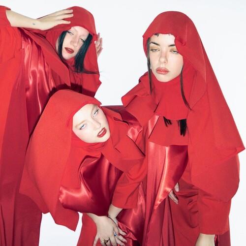 Three women in red hooded satin outfits posing against a white background