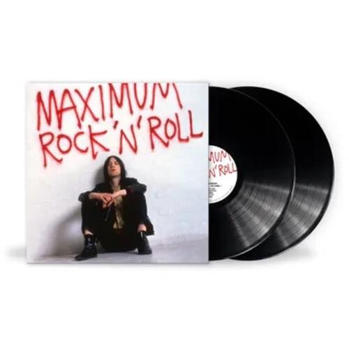 White album sleeve with red handwritten text and a seated figure, with two black vinyl records