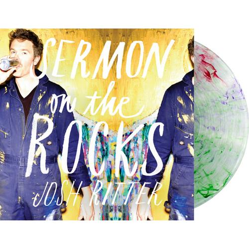 Clear vinyl LP with red, purple, and green swirls next to a yellow album cover featuring a man in bl