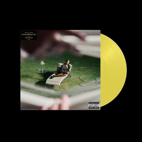 Yellow vinyl LP record partially removed from album sleeve featuring a woman lounging on a white cha