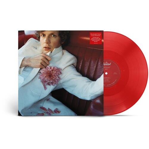 Red translucent vinyl record partially removed from album sleeve featuring a man in a white suit