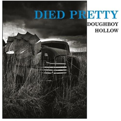 Black and white album cover featuring a vintage truck in tall grass under a cloudy sky