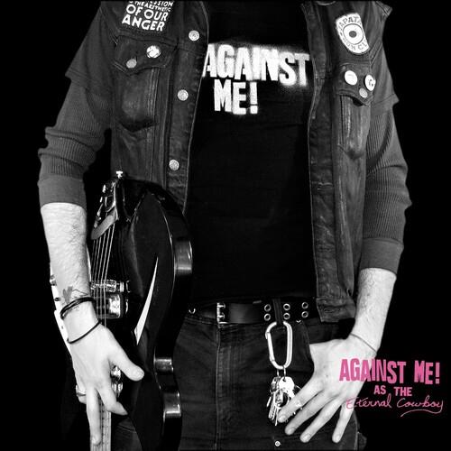 Black and white photo of a person wearing a denim vest and holding a guitar
