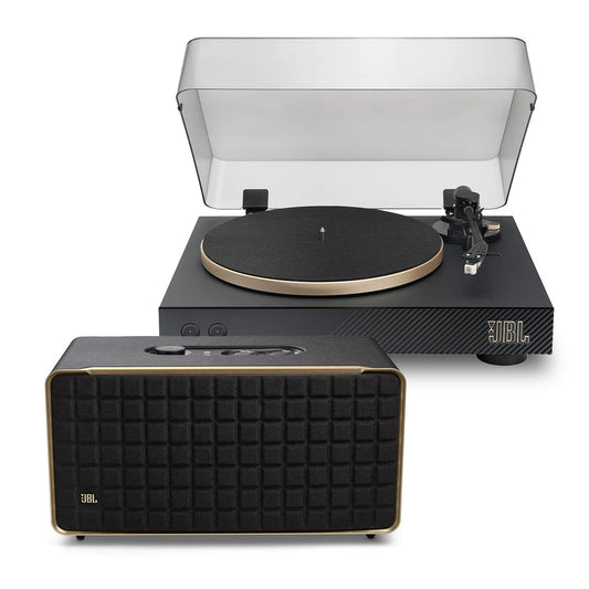 Black turntable with clear dust cover and gold-tone platter edge paired with a black rectangular spe