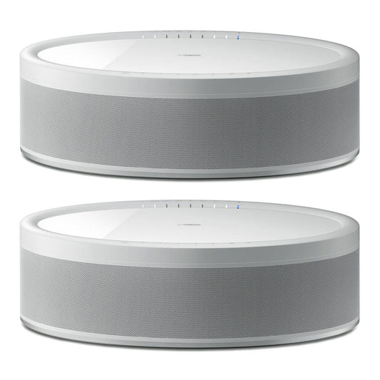 Pair of white oval wireless speakers with perforated metal grilles and touch controls
