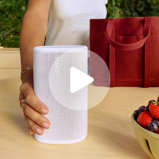 White cylindrical portable speaker with mesh grille and top controls