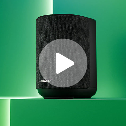 Black Bose portable speaker with mesh grille and white play button overlay
