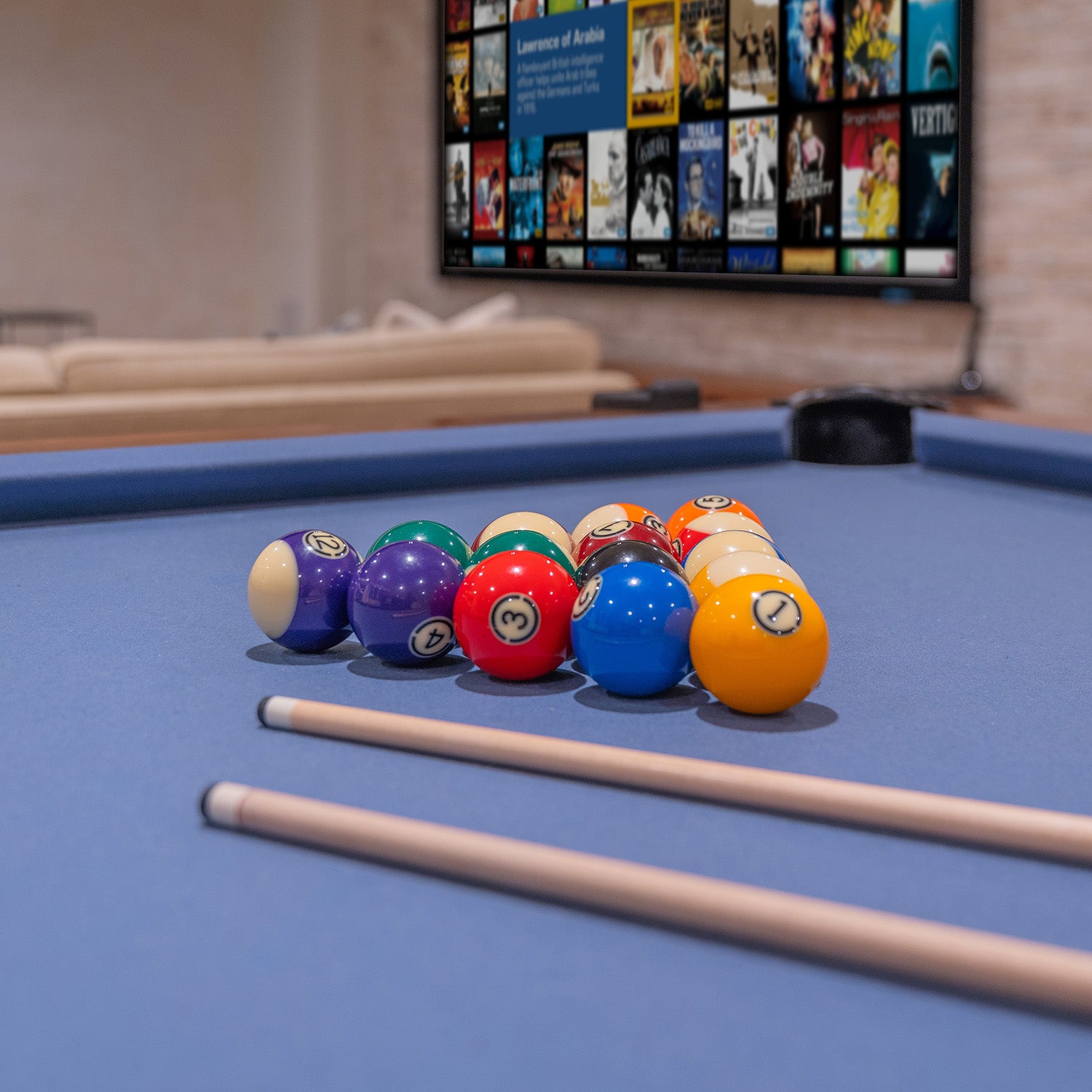 Close-up of billiard balls and pool cues with home theater screen in the background in Chestnut Hill, PA