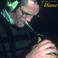 Close-up of a musician playing a saxophone while wearing headphones and glasses