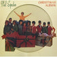 Vintage Christmas album cover featuring a group of singers in colorful sweaters emerging from a larg