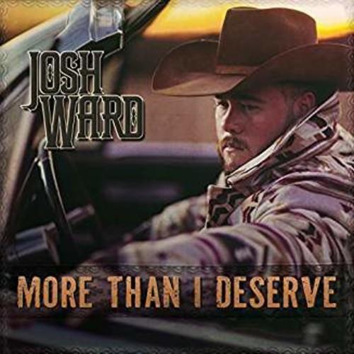 Cowboy in a brown hat and plaid shirt sitting in a truck at sunset