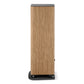 Tall floorstanding speaker with a light wood grain finish and black base