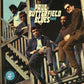 Vintage vinyl LP cover featuring a band posing on wooden stairs with bold typography