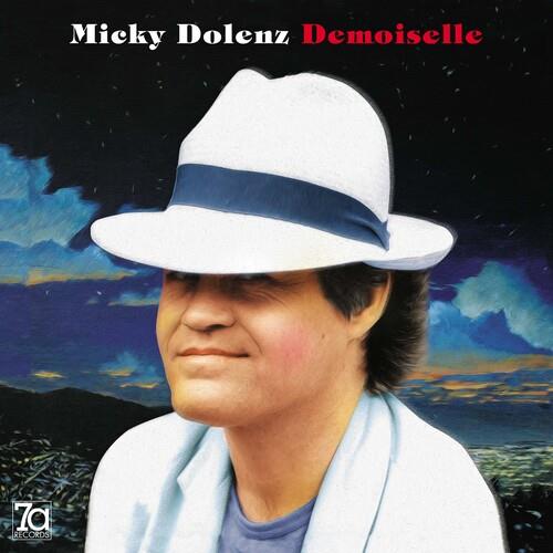 Man wearing a white fedora with a blue band against a painted night sky background