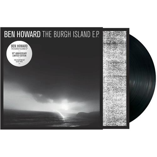 Black vinyl record partially removed from a black and white album sleeve featuring a coastal landsca