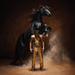 Gold-clad figure with fringed mask standing before a rearing black horse