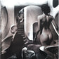 Surrealist black and white collage featuring a suited man, a nude woman, and abstract architectural 