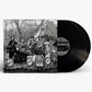 Black and white album cover featuring a band on a decorated stage with two black vinyl records