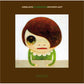 Illustrated character with brown hair and a green dress on a brown album cover